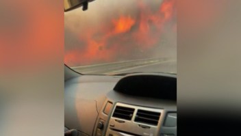 Auto avanza por carretera flanqueada por incendios forestales en Italia