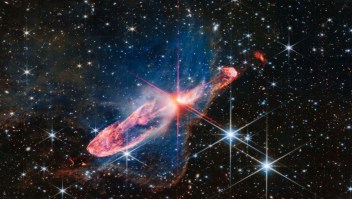 El telescopio espacial James Webb captó una imagen de alta resolución de un par de estrellas en formación activa llamadas Herbig-Haro 46/47. El dúo estelar, de solo unos pocos miles de años de edad, se encuentra en el centro de los picos rojos de difracción. (Crédito: J. DePasquale/CSA/ESA/NASA)