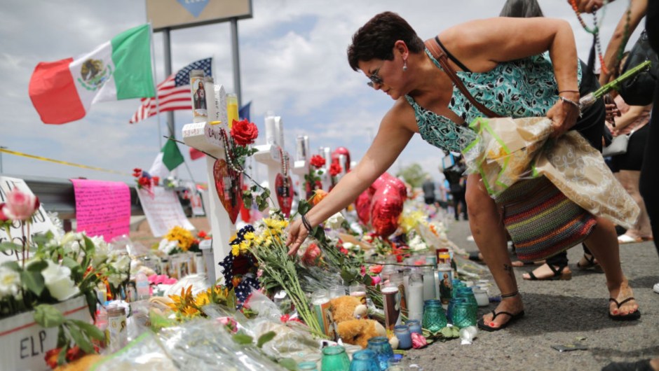 Una mujer coloca flores mientras ondea banderas mexicanas y estadounidenses durante un homenaje improvisado a las víctimas frente a un Walmart cerca del lugar del tiroteo masivo que dejó 23 muertos el 6 de agosto de 2019 en El Paso, Texas. .  (Foto: Mario Tama/Getty Images)