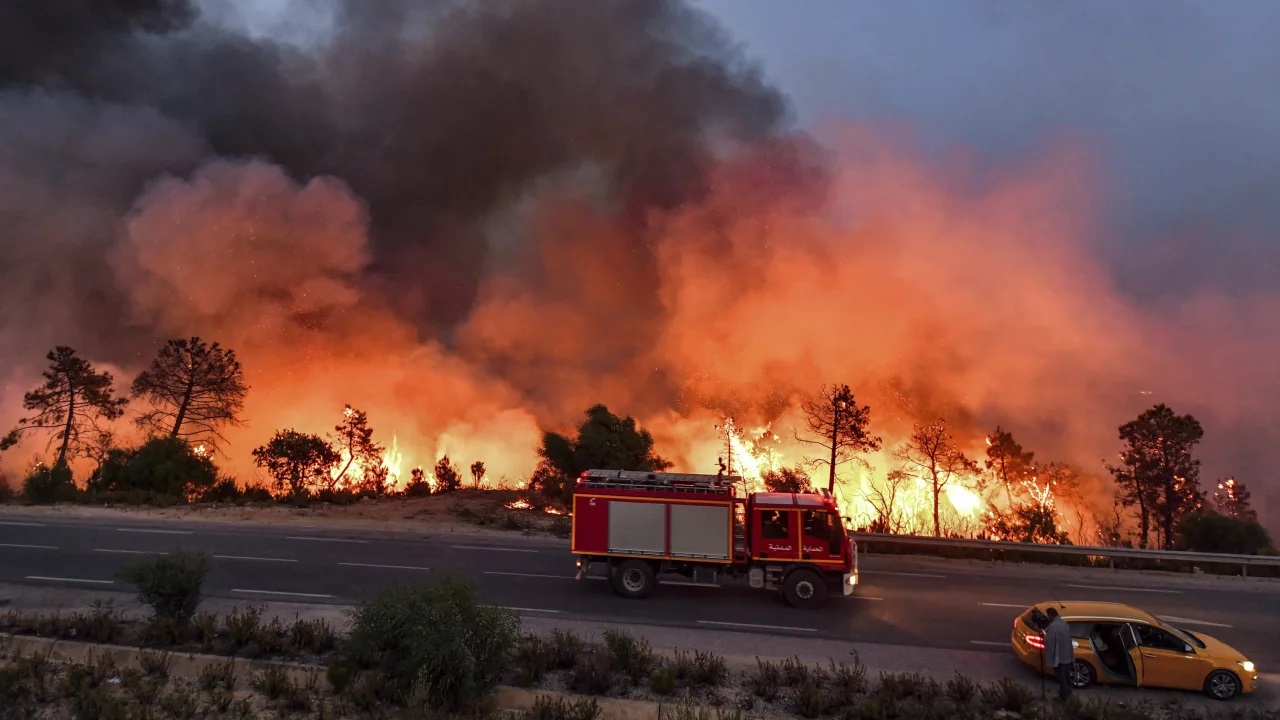 Un camión de bomberos avanza por una carretera mientras un incendio forestal arrasa cerca de la ciudad de Melloula, en el noroeste de Túnez, el 24 de julio.