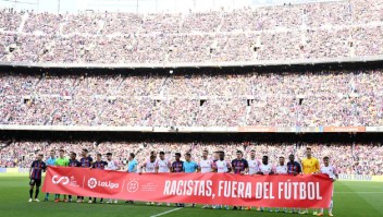 Futbolistas de Barcelona y Mallorca portan una bandera contra el racismo en el fútbol.