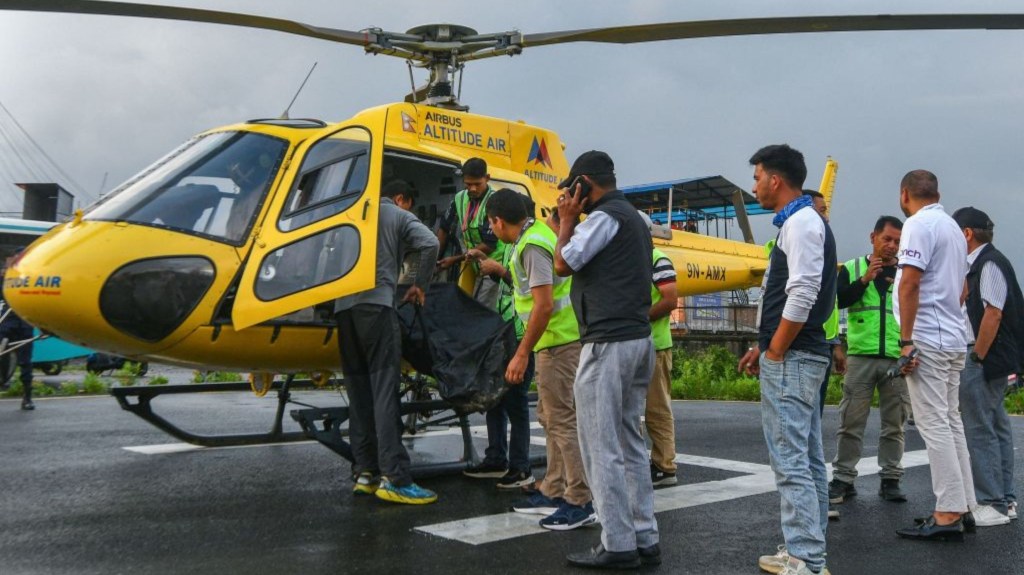 People lower the body of a man who died in a helicopter crash in Nepal on Tuesday, July 11, 2023.  A tourist helicopter crashed in Nepal shortly after takeoff from the Everest region on July 11, killing six people on board.  For Aviation Officers.  (Photo: Prakash Mehdima/AFP via Getty Images)