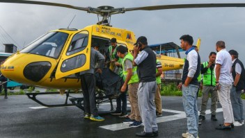 Varias personas bajan el cuerpo de una víctima fallecida en un accidente de helicóptero en Nepal este martes 11 de julio de 2023. Las seis personas que iban a bordo de un helicóptero turístico en Nepal murieron al estrellarse poco después de despegar en la región del Everest el 11 de julio, según informaron las autoridades de aviación. (Foto: PRAKASH MATHEMA/AFP vía Getty Images)