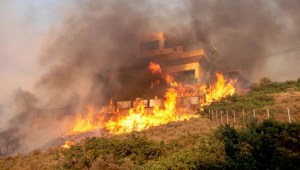 Las llamas envuelven una casa mientras arde un incendio forestal en Saronida, cerca de Atenas, Grecia, el lunes. (Foto: Stelios Misinas/Reuters)