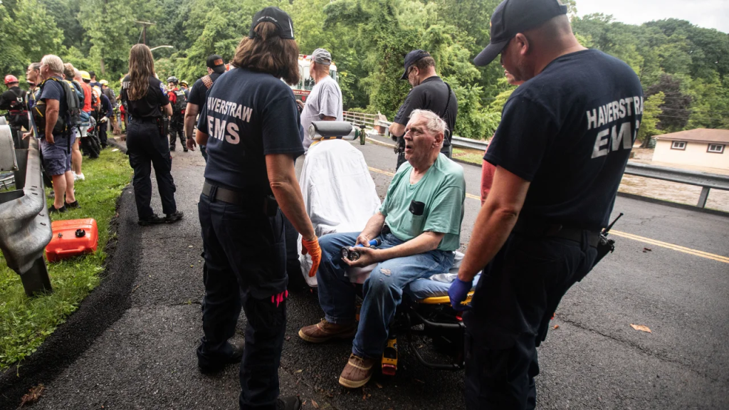 El personal de emergencia atiende a un residente de una vivienda en Stony Point, Nueva York, tras rescatarlo de su casa inundada este domingo. (Foto: Seth Harrison/The Journal News/USA Today Network)