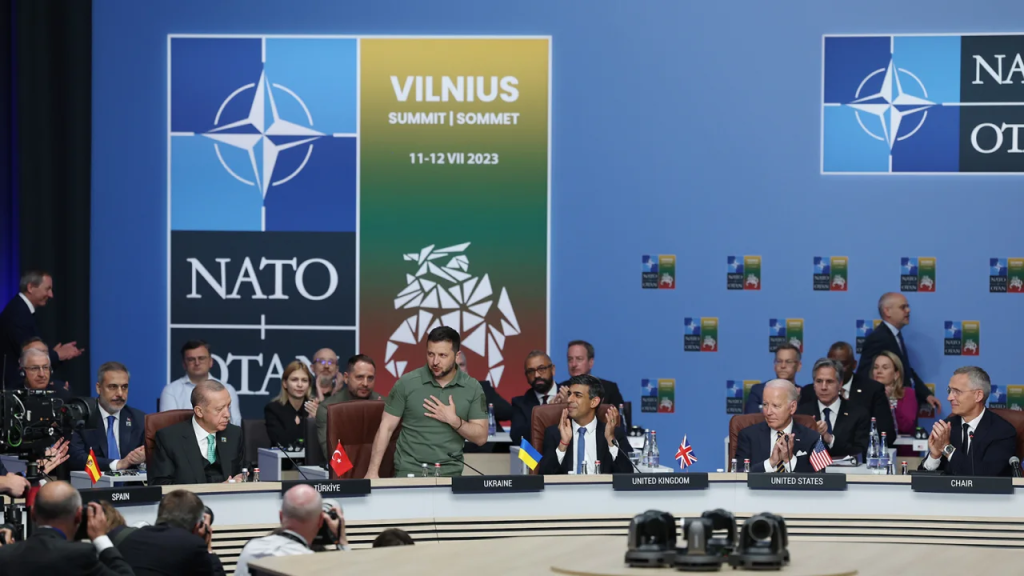 El presidente de Ucrania, Volodymyr Zelenskyy (segundo a la izquierda), aplaudido por el presidente de Turquía, Recep Tayyip Erdogan (izquierda), el primer ministro de Reino Unido, Rishi Sunak (tercero a la derecha), y el presidente de Estados Unidos, Joe Biden (segundo a la derecha), durante su presentación en una reunión del Consejo OTAN-Ucrania celebrada durante la Cumbre de la OTAN en Vilna el 12 de julio de 2023. (Foto: Murat Kula/Anadolu Agency/Getty Images)