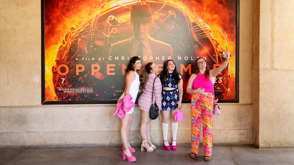 De izquierda a derecha, Gabrielle Roitman, Kayla Seffing, Maddy Hiller y Casey Myer se toman una selfie delante de un cartel de la película "Oppenheimer" antes de asistir a una proyección anticipada de "Barbie" el jueves en Los Ángeles. (Foto: Chris Pizzello/AP)