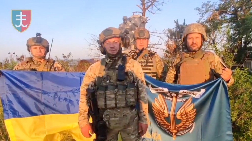 Soldados ucranianos con la bandera de Ucrania en Urozhaine, región de Donetsk, Ucrania, en esta captura de pantalla obtenida de un video difundido el 16 de agosto. (Crédito: Fuerzas Armadas de Ucrania/Reuters)