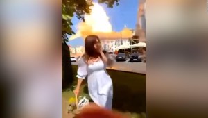 Un misil ruso impacta mientras una mujer sonríe a la cámara