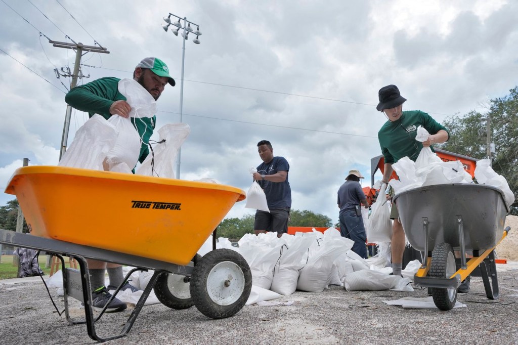 Miembros del Departamento de Parques y Recreación de Tampa ayudan a los residentes con sacos de arena el 28 de agosto. (Foto: Chris O'Meara/AP)