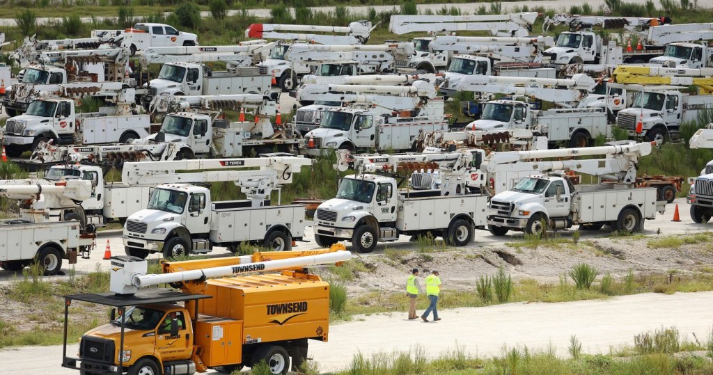 Técnicos eléctricos caminan entre cientos de camiones de líneas eléctricas en la ubicación de Duke Energy en Sumterville, Florida, el 29 de agosto. (Foto: Stephen M. Dowell/Orlando Sentinel/AP)
