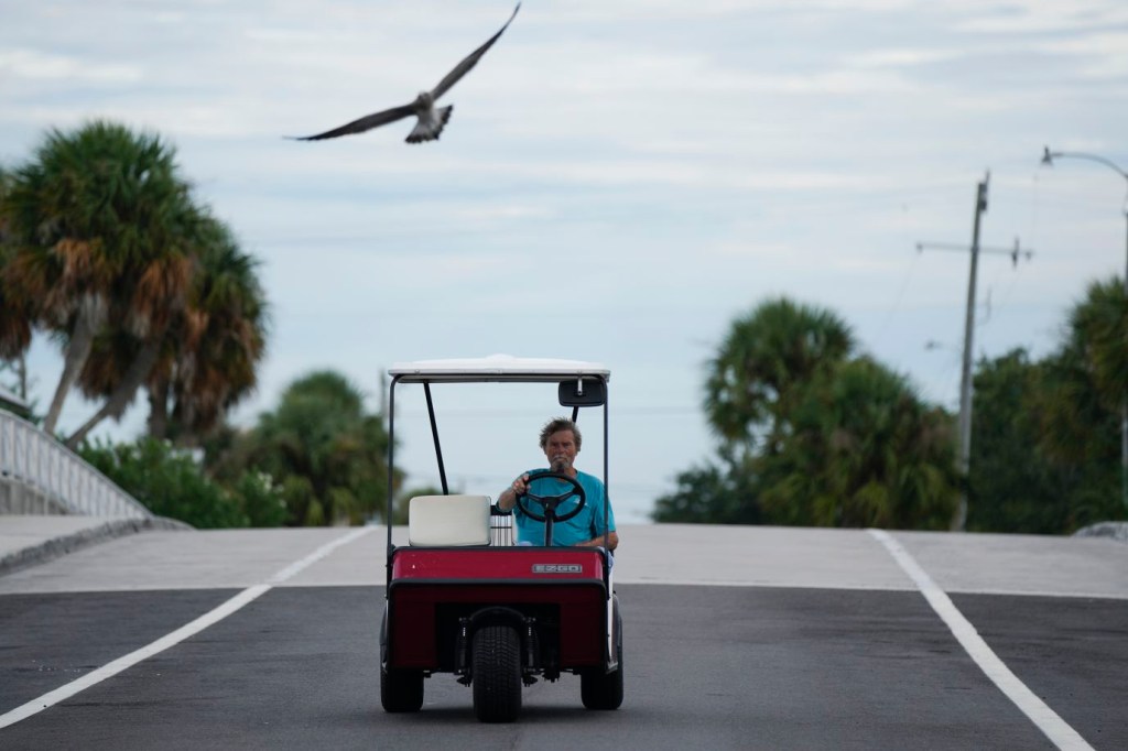 Un residente conduce su carrito de golf sobre un puente en Cedar Key, Florida, el 29 de agosto, un día antes de la llegada de Idalia. (Foto: Rebecca Blackwell/AP)