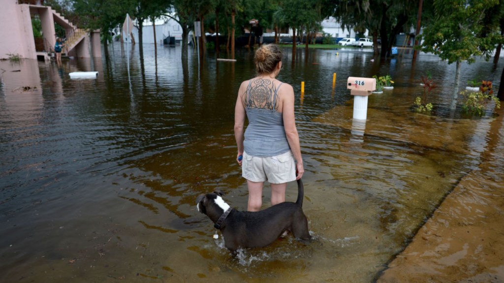 Kyan Watson y su perro Brandon contemplan las aguas de la inundación del huracán Idalia que rodea su casa el 30 de agosto de 2023 en Tarpon Springs, Florida. (Foto: Joe Raedle/Getty Images)