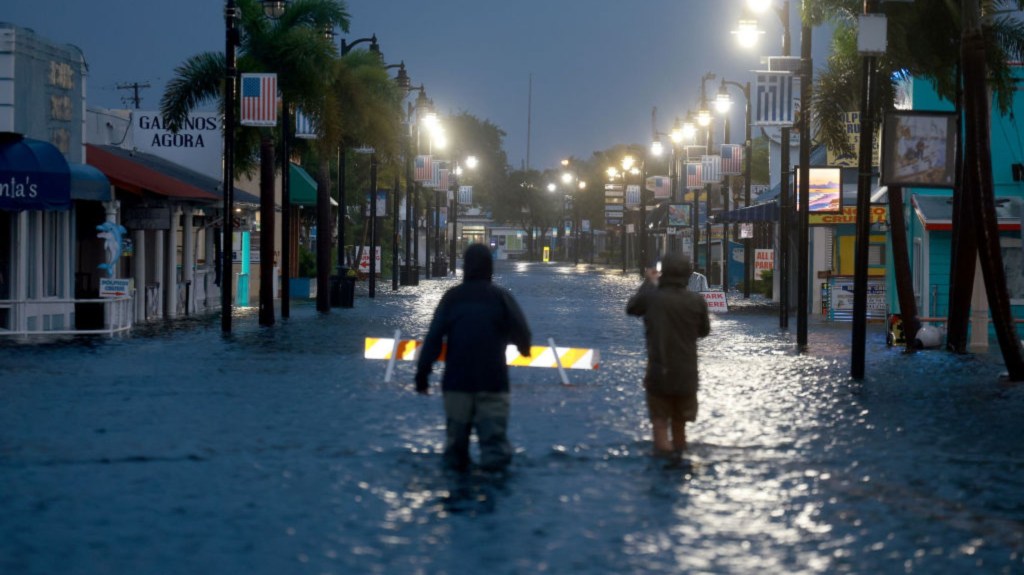 Reporteros caminan a través de las aguas de inundación, que inundan el centro de la ciudad después de que el huracán Idalia pasara mar adentro el 30 de agosto de 2023 en Tarpon Springs, Florida. (Foto: Joe Raedle/Getty Images)