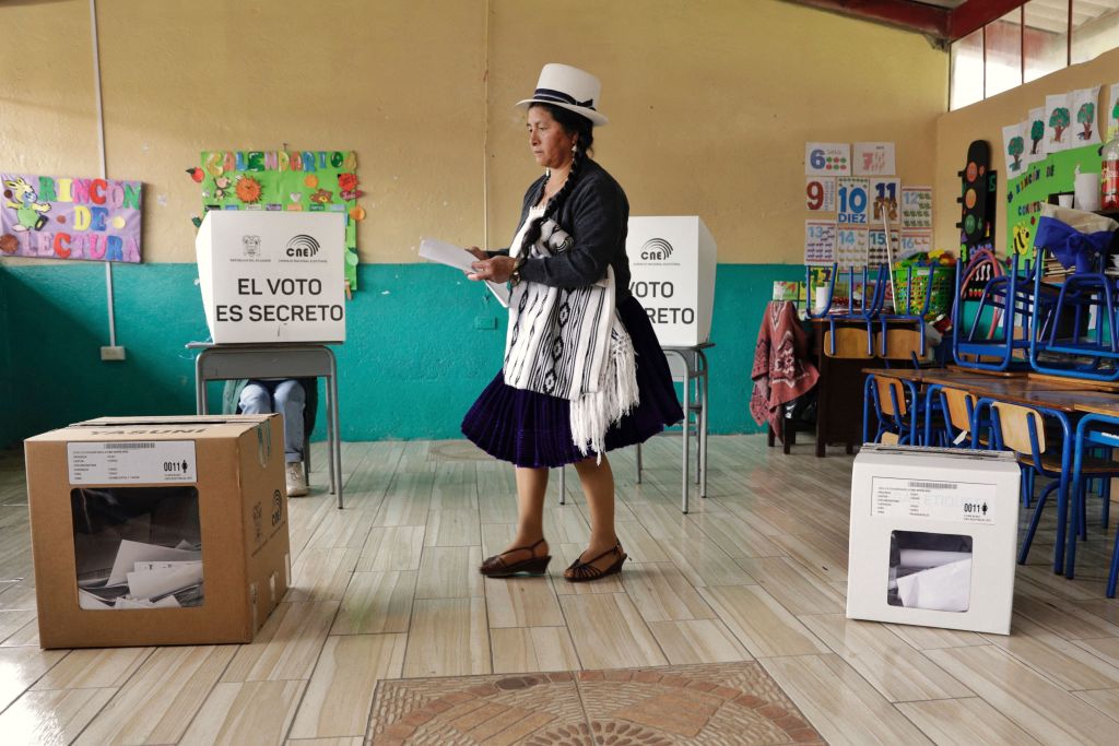 Una mujer indígena deposita su voto en un colegio electoral de Tarqui, cantón de Cuenca, provincia de Azuay, durante las elecciones presidenciales y el referéndum sobre minería y petróleo. (Crédito: Cristina Vega/AFP vía Getty Images)