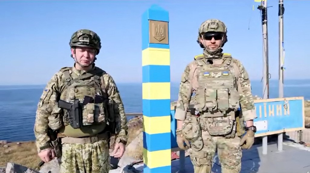 Guardias fronterizos ucranianos junto a una señal fronteriza recién instalada en la isla de las Serpientes, en esta captura de pantalla de un video publicado en redes sociales el 12 de agosto. (Foto: Serhiy Deineko, jefe del Servicio de Fronteras/Reuters)