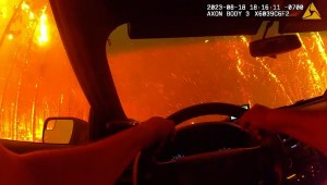 Policía se salva por poco en una carretera en llamas