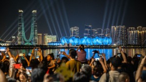 La gente se reúne en el paseo del río Qiantang para ver el espectáculo de luces previo a los Juegos Asiáticos en Hangzhou, China, el 19 de septiembre. (Philip Fong/AFP/Getty Images)