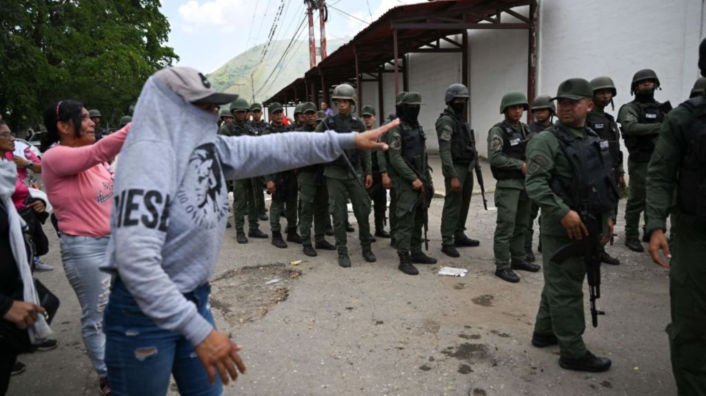 Miembros de la Guardia Nacional Bolivariana (GNB) montan guardia mientras los familiares esperan noticias después de que las autoridades tomaran el control de la prisión de Tocorón en Tocorón, estado de Aragua, Venezuela, el 20 de septiembre de 2023. (Foto: YURI CORTEZ/AFP vía Getty Images)