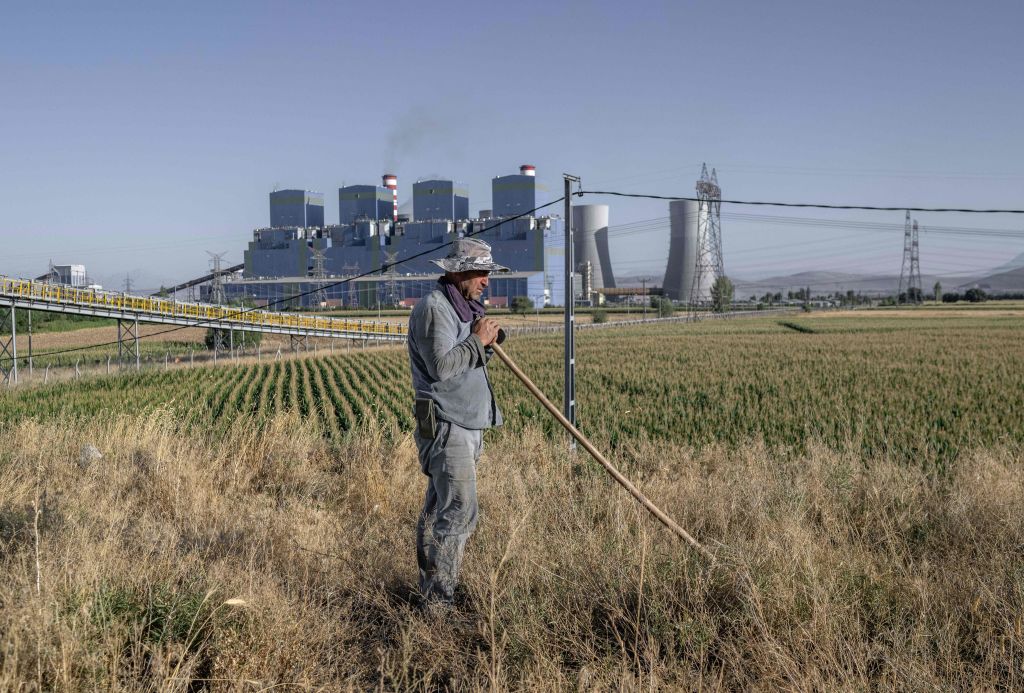 El agricultor turco Yusuf Avci trabaja en su campo cerca de la central eléctrica de carbón de Afsin, en Afsin, en la provincia de Kahramanmaras, al sur de Turquía, el 22 de agosto de 2023. (Foto: BULENT KILIC/AFP vía Getty Images)
