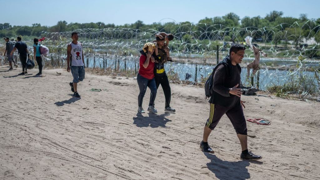 Inmigrantes caminan hacia un área de procesamiento después de cruzar río Grande desde Mexico (Crédito: ANDREW CABALLERO-REYNOLDS/AFP via Getty Images)