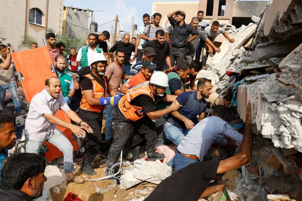 Palestinos buscan entre los escombros de una casa en Khan Younis destruida por ataques aéreos israelíes el 8 de octubre. (Crédito: Ibraheem Abu Mustafa/Reuters)