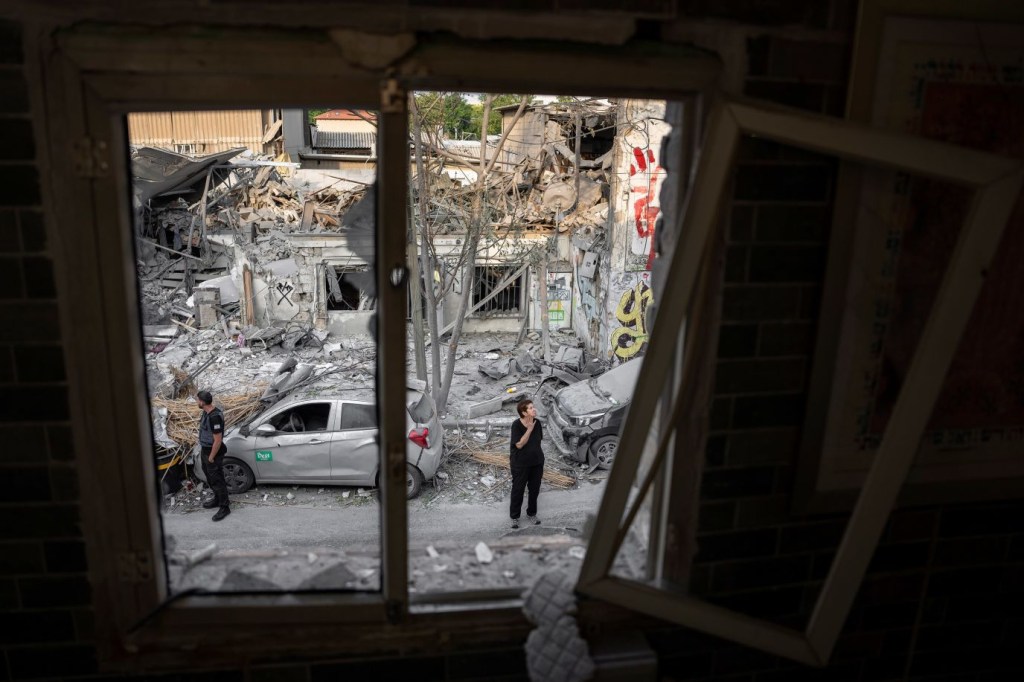 Israelíes inspeccionan los escombros de un edificio en Tel Aviv el 8 de octubre, un día después de que fuera alcanzado por un cohete lanzado desde Gaza. (Crédito: Oded Balilty/AP)