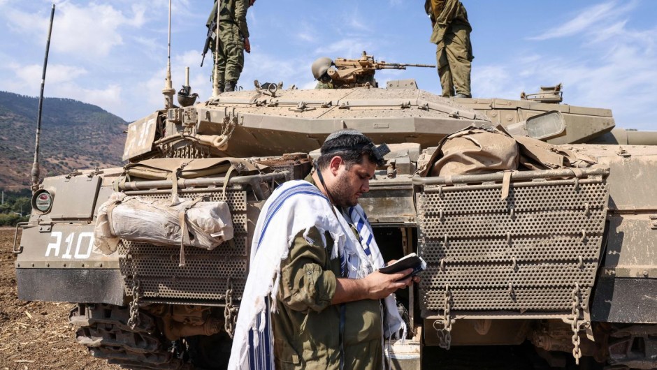 Un soldado israelí reza frente a un tanque en las afueras de la ciudad septentrional de Kiryat Shmona, el 8 de octubre. (Crédito: Jalaa Marey/AFP/Getty Images)