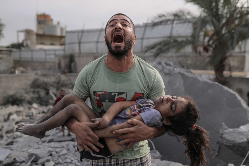 Un palestino carga el cuerpo de su prima, que fue sacada de entre los escombros tras los ataques aéreos israelíes en la ciudad de Gaza el lunes 9 de octubre. (Crédito: Belal Khaled/Anadolu Agency/Getty Images)