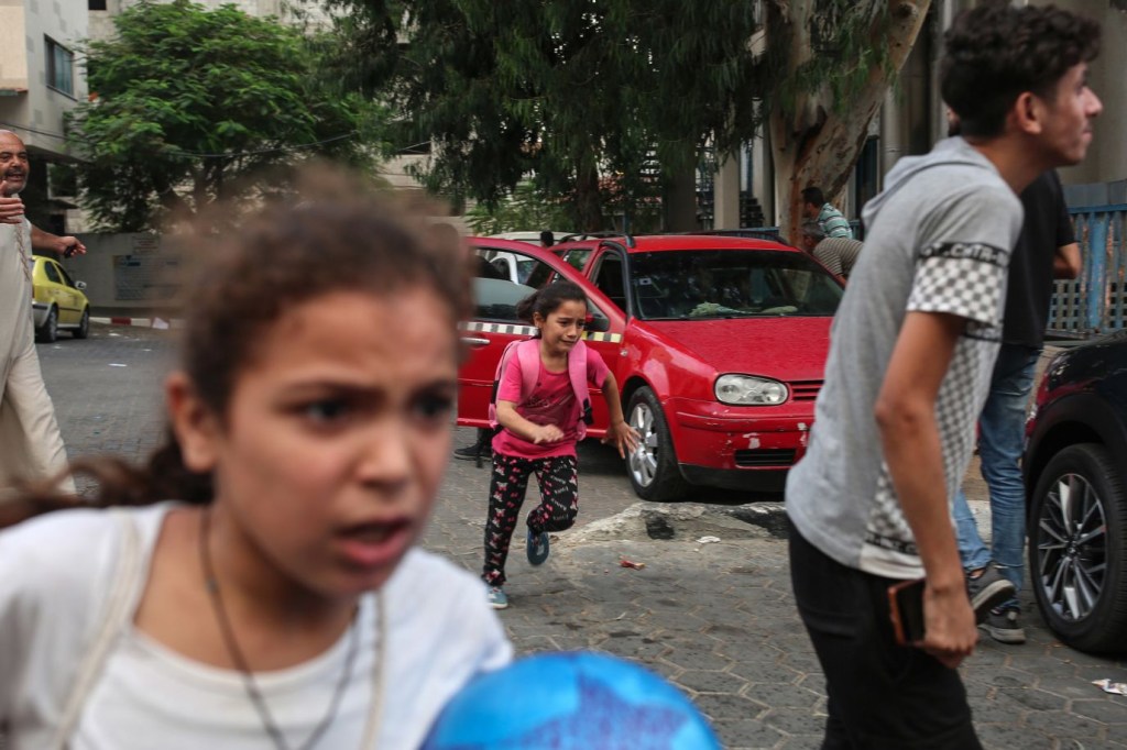 Niñas corren para protegerse mientras caen bombas cerca del hospital Al-Shifa, en la ciudad de Gaza, el 9 de octubre. (Crédito: Samar Abu Elouf/The New York Times/Redux)