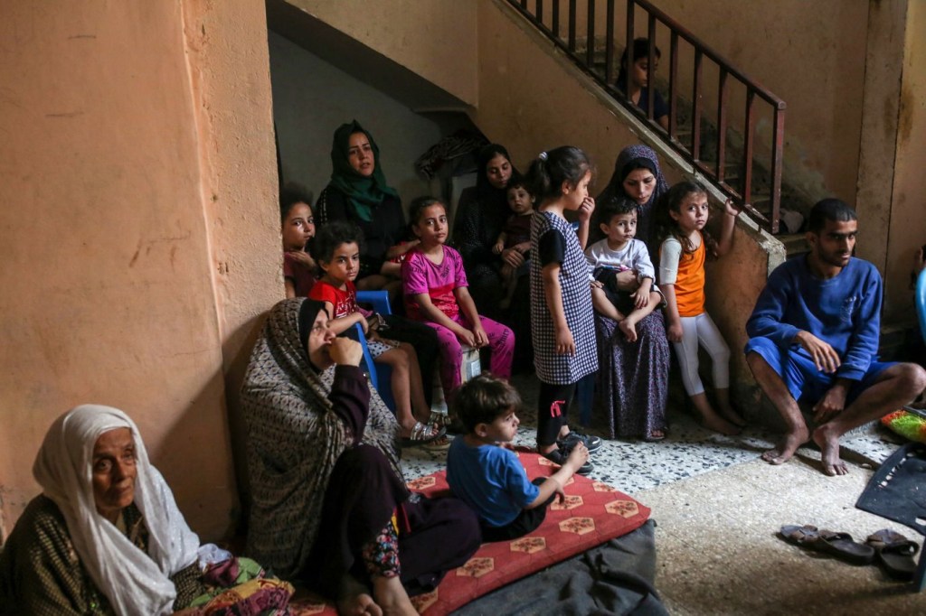 Una familia se refugia en casa de un vecino después de que su vivienda resultara dañada por un ataque aéreo israelí en el campo de refugiados de Shati, en Gaza, el 9 de octubre. (Crédito: Samar Abu Elouf/The New York Times/Redux)