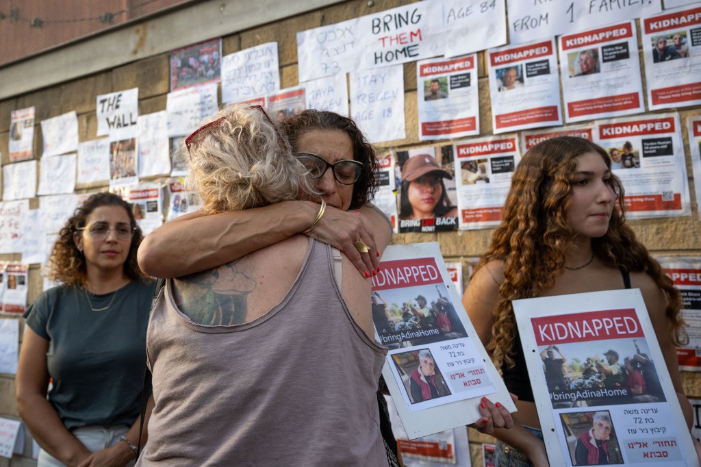 Einav Moshe Barda, sobrina de Adina, una de las personas secuestradas, abraza a una mujer después de contar la historia de su familia el sábado 14 de octubre frente a HaKirya, el cuartel gubernamental y militar de Tel Aviv, Israel. (Crédito: Alexi J. Rosenfeld/Getty Images)