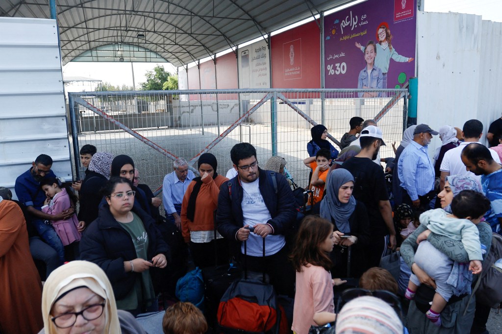 Le persone si radunano sul lato di Gaza del valico di frontiera di Rafah il 14 ottobre.  (Credito: Ibrahim Abu Mustafa/Reuters)