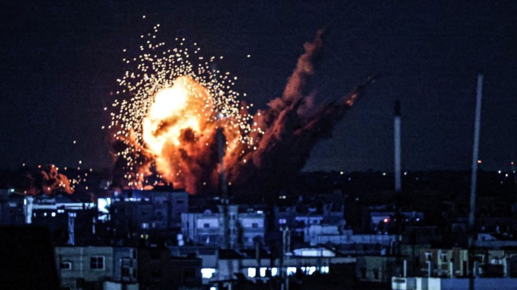 Una bola de fuego y humo se eleva sobre los edificios durante un ataque israelí en Rafah, en el sur de Gaza, el 15 de octubre de 2023. (Crédito: SAID KHATIB/AFP vía Getty Images)