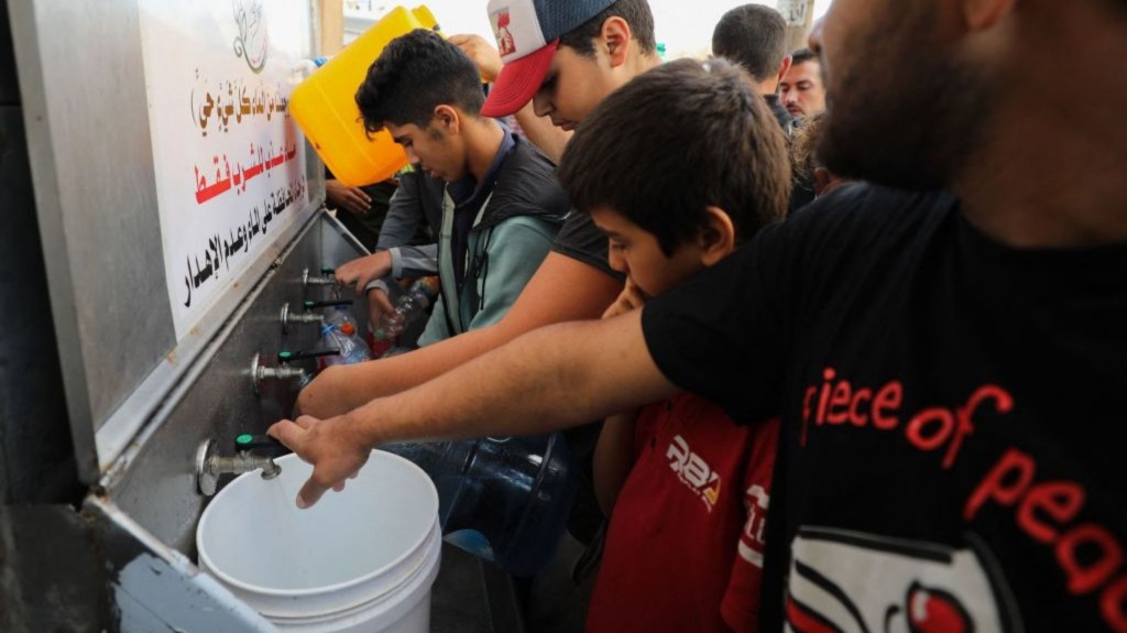 Palestinians line up to fill water cannisters in Gaza City, on October 16, 2023. (Crédito: DAWOOD NEMER/AFP vía Getty Images)