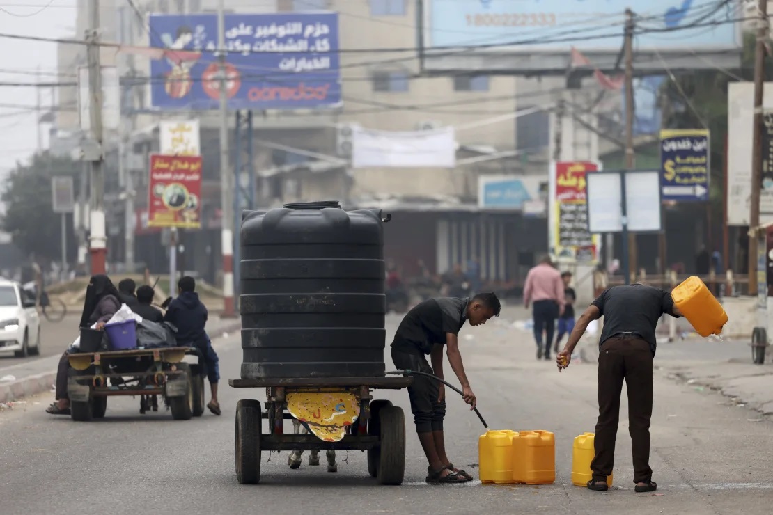 Varias personas llenan contenedores de plástico con agua potable en Rafah, en el sur de la Franja de Gaza, el 23 de octubre de 2023.