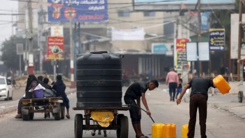 Varias personas llenan contenedores de plástico con agua potable en Rafah, en el sur de la Franja de Gaza, el 23 de octubre de 2023.