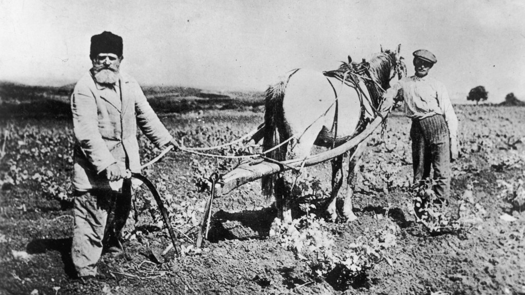 Un hombre y un niño trabajan la tierra en un kibutz en 1912.