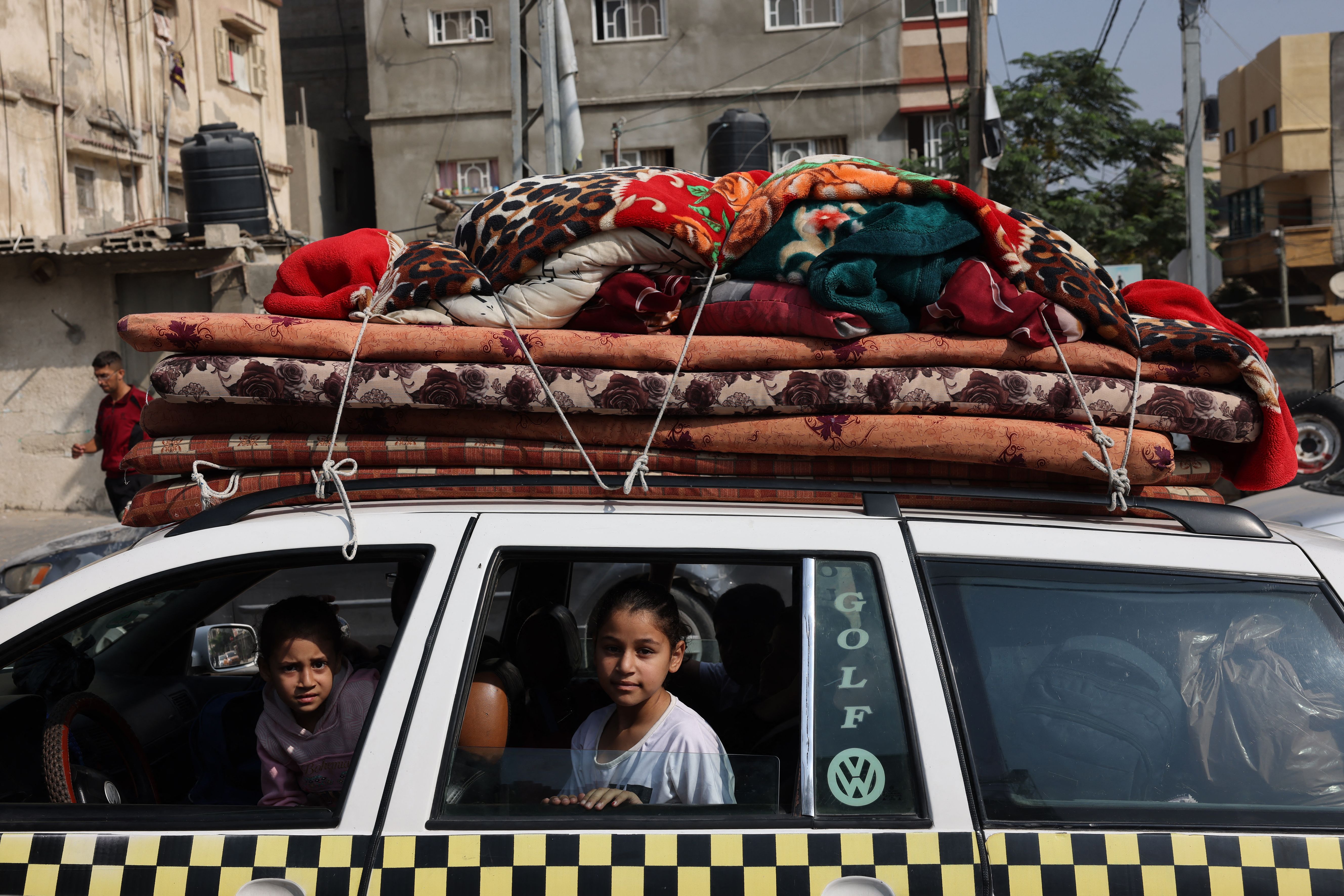 Niños palestinos sentados en un vehículo cargado con artículos para el hogar en el campo de refugiados de Khan Younis, en Khan Younis, en el sur de Gaza, el 28 de octubre. Mohammed Abed/AFP/Getty Images