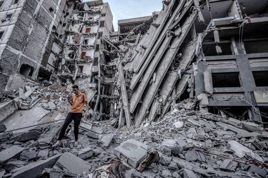Una persona camina entre los escombros de un edificio destruido en la ciudad de Gaza, el domingo 8 de octubre. (Crédito: Ali Jadallah/Agencia Anadolu/Getty Images)