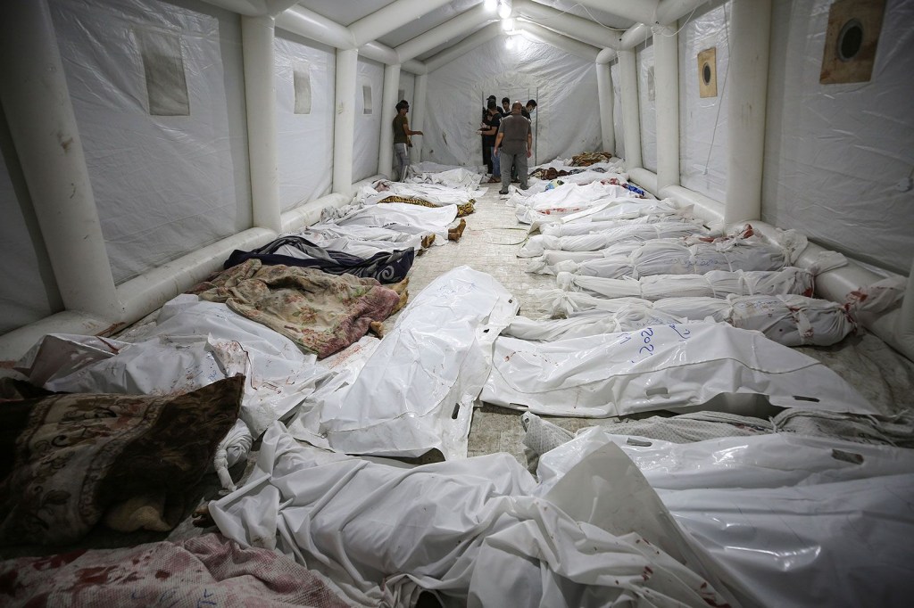 Los cuerpos de los palestinos muertos en la explosión yacen frente al hospital Al-Shifa en la ciudad de Gaza. (Abed Khaled/AP)