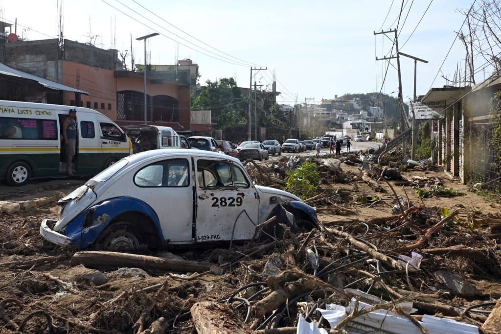 Un VW Beetle entre escombros en el área de la playa luego del paso del huracán Otis en Acapulco, estado de Guerrero, México, el 27 de octubre de 2023. (FRANCISCO ROBLES/AFP via Getty Images)