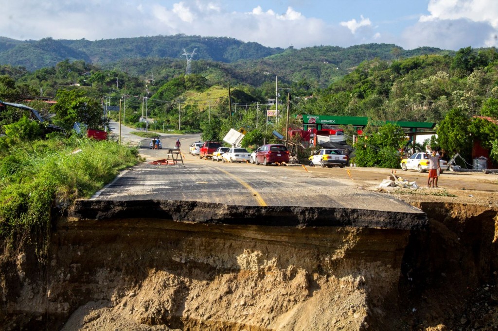 La gente conduce sus automóviles cerca de una carretera dañada después de que Otis azotara Acapulco el 26 de octubre de 2023 en Acapulco, México. Otis tocó tierra por la costa de Acapulco la madrugada del 25 de octubre como huracán categoría 5. (Oscar Guerrero Ramirez/Getty Images)