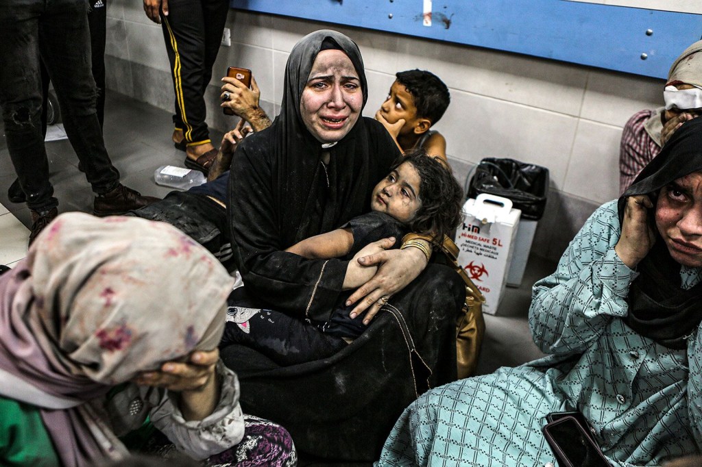 Palestinos heridos sentados en el suelo del Hospital Al-Shifa después de ser transportados desde el Hospital Bautista Al-Ahli, donde cientos murieron en una explosión el martes 17 de octubre de 2023. (Abed Khaled/AP)