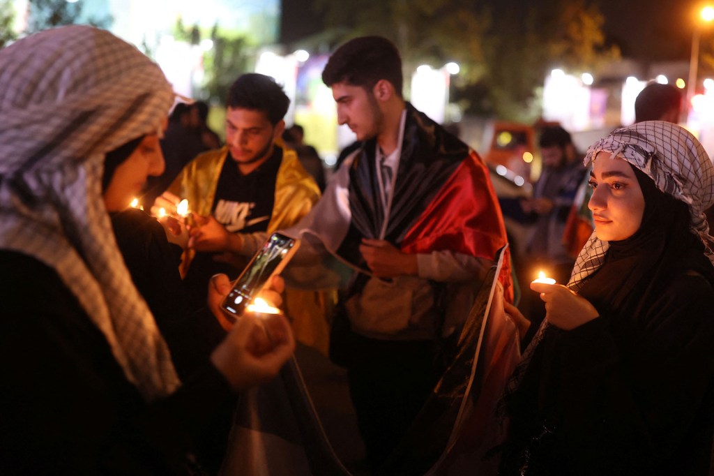 La gente enciende velas durante una reunión en apoyo de los palestinos, en Teherán, Irán, el 17 de octubre de 2023. (Majid Asgaripour/WANA/Reuters)