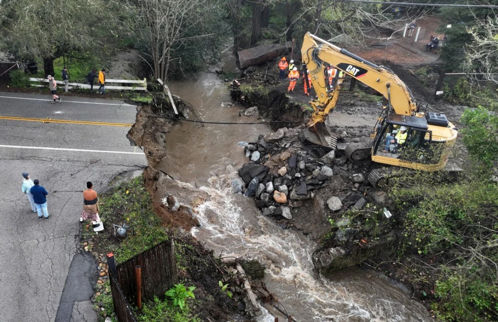 Los trabajadores realizan reparaciones de emergencia en una carretera que fue arrasada por las fuertes lluvias el 10 de marzo de 2023 en Soquel, California. (Justin Sullivan/Getty Images)