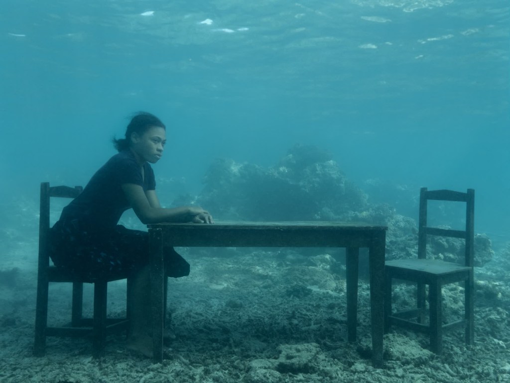 Serafina está sentada en una mesa frente a una silla vacía, un detalle que, según Brandt, da aún más fuerza a la imagen.