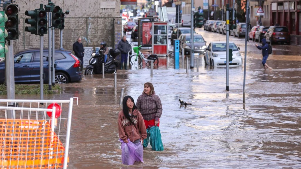 Dos mujeres en una intersección inundada en Milán después de que una violenta tormenta azotara la ciudad el 31 de octubre de 2023. (Crédito: Vasile Mihai-Antonio/Getty Images)