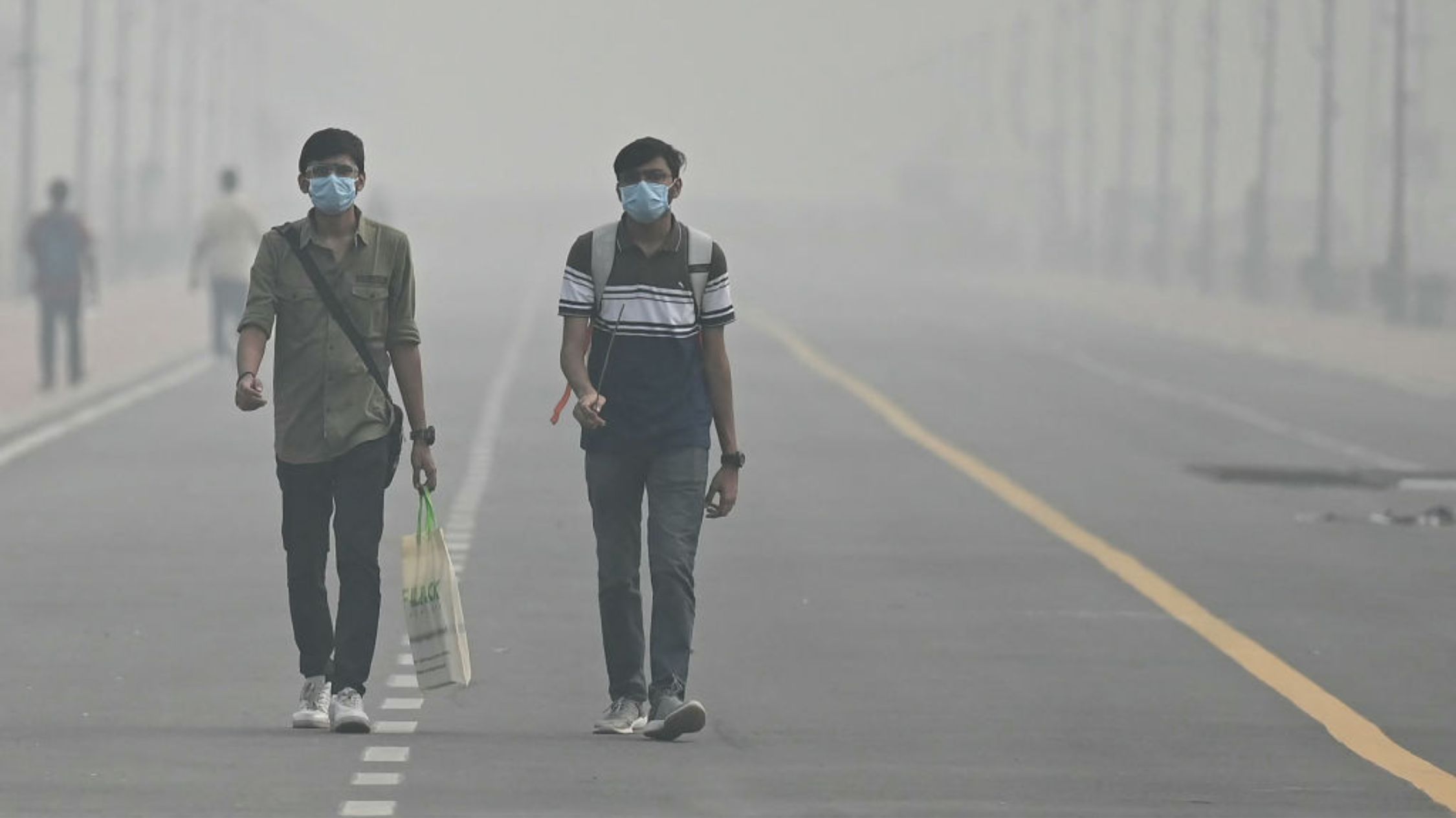 Masked people walk on Kartavya Road amid heavy pollution in New Delhi, India on November 5, 2023.  (Credit: ARUN SANKAR/AFP via Getty Images)