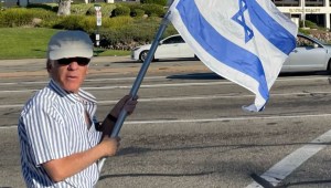Esta foto, tomada este domingo, muestra a Paul Kessler sosteniendo una bandera israelí en la intersección donde más tarde tendría lugar el altercado. (Crédito: X, antes Twitter)